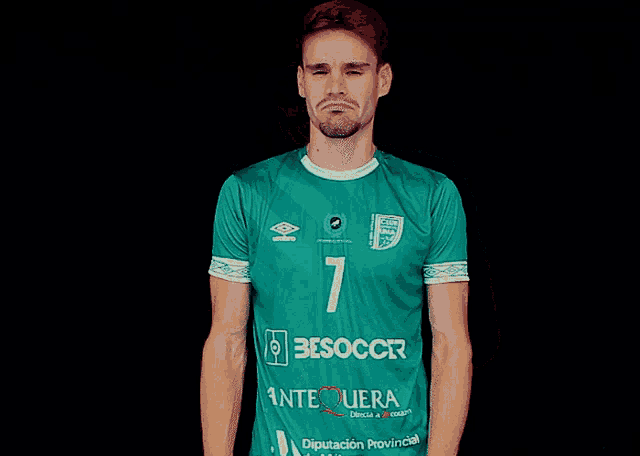 a man wearing a green jersey with the number 7