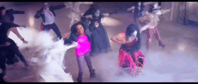 a group of people are dancing in a room with smoke coming out of them .