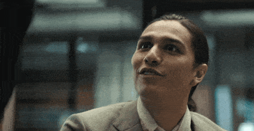 a close up of a man 's face with a ponytail