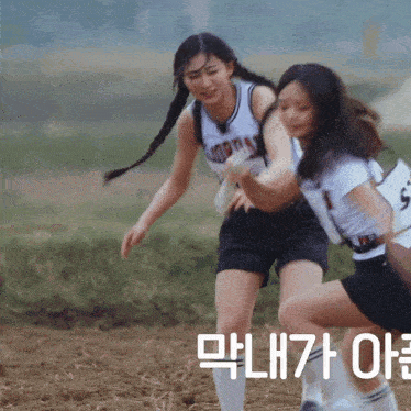 two girls are playing soccer and one has the number 5 on her shirt