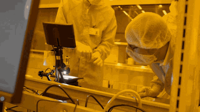 a man in a lab coat looks at a computer monitor