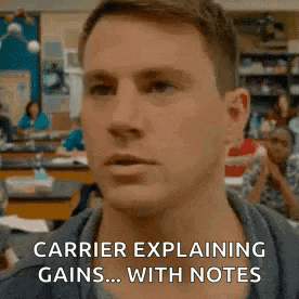 a man is explaining gains with notes in a classroom while sitting at a desk .