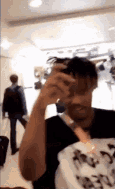 a man in a black shirt is taking a picture of himself in a mirror .
