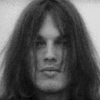 it is a black and white photo of a man with long hair .