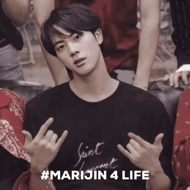a young man wearing a saint laurent t-shirt is giving a peace sign