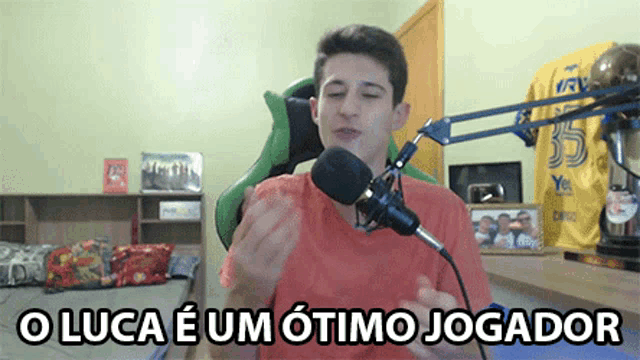a young man sitting in front of a microphone with the words o luca e um otimo jogador written below him