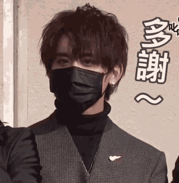 a close up of a man wearing a black mask and a suit .