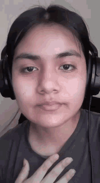 a woman is wearing headphones and making a funny face .