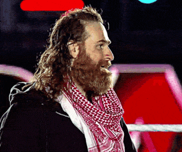 a man with a beard wearing a scarf around his neck