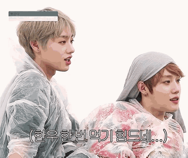 two young men are standing next to each other and one of them is wearing a plastic cover over his head
