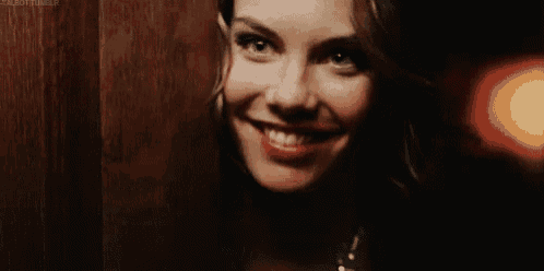a close up of a woman 's face with red lipstick and a wooden background .