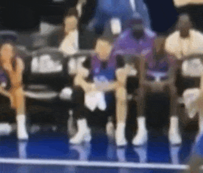 a blurry picture of a group of people sitting on a bench .