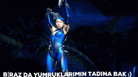 a woman in a blue suit is standing in front of a blue light and the words biraz da yumruklarimin tadina bak