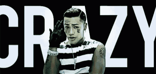 a man with a tattoo on his face is standing in front of a sign that says crazy