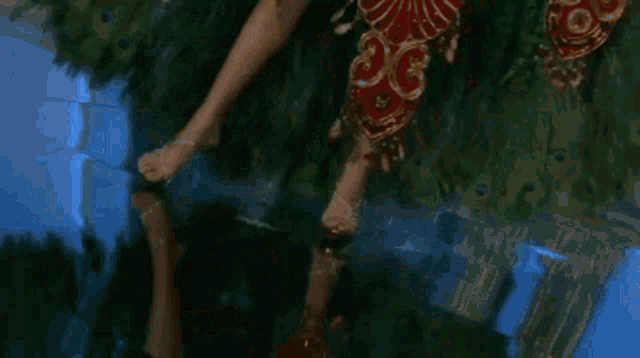 a close up of a red and gold necklace on a green dress