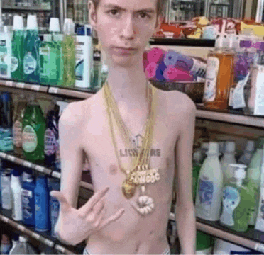 a shirtless man wearing a gold necklace with the word lion on his chest