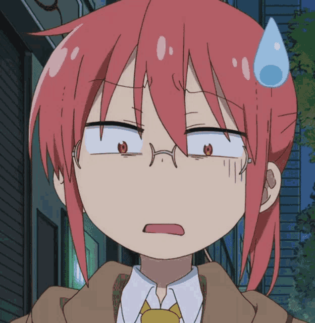 a close up of a girl with red hair and glasses making a funny face