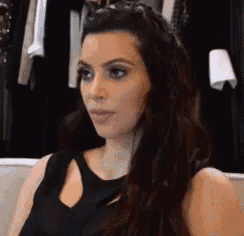 a woman with long hair is sitting on a couch in front of a closet .