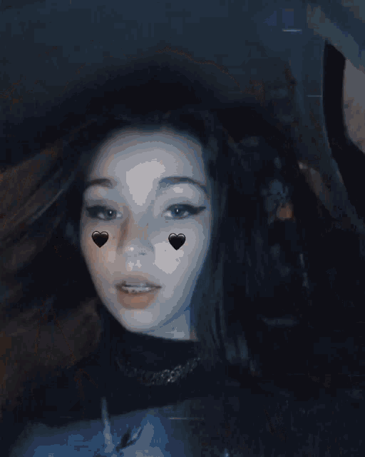 a girl with black hearts on her face looks at the camera