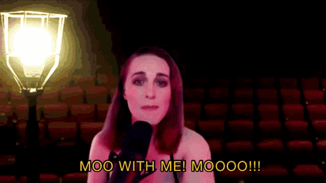 a woman singing into a microphone with the words moo with me ! moooo !!! below her