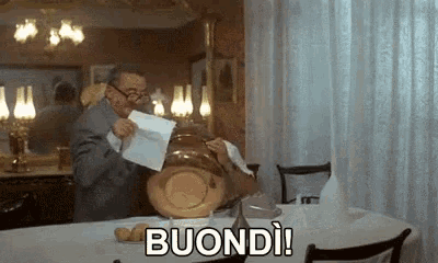 a man is sitting at a table in a restaurant holding a piece of paper that says buondi !