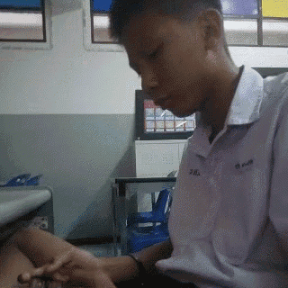 a young man in a fila shirt is sitting at a table