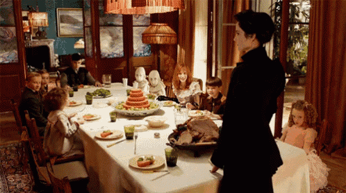 a woman stands in front of a long table with a turkey on it