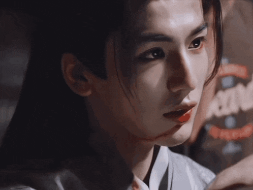 a close up of a man 's face with a bloody wound