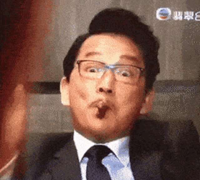 a man in a suit and tie is making a funny face with his mouth open