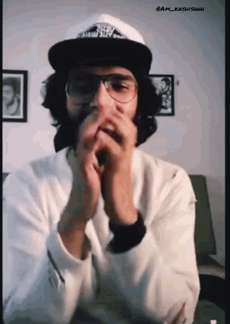 a man wearing glasses and a hat with a vans logo