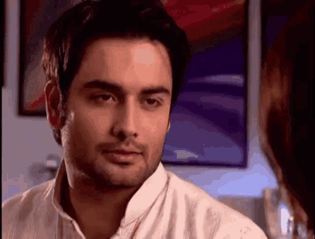 a man in a white shirt is looking at a woman