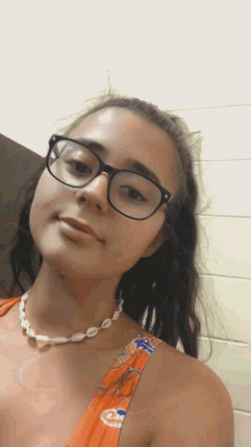 a girl wearing glasses and a necklace with shells