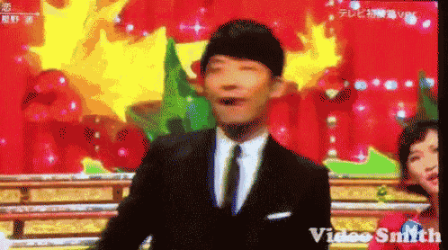 a man in a suit and tie is standing in front of a screen that says video smith on it