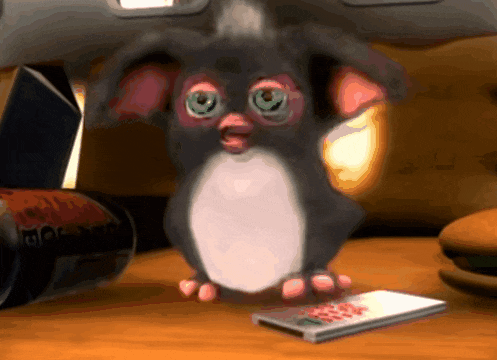 a cartoon gizmo is standing next to a remote control and a can of coca cola