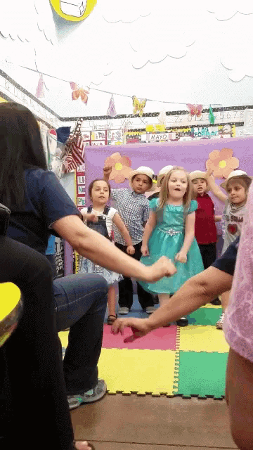 a group of children are dancing in a classroom with a sign that says ' a ' on it