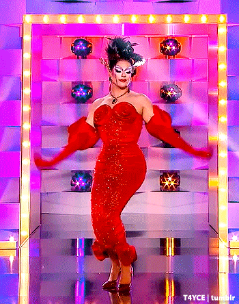 a drag queen in a red dress and red gloves is dancing on stage .