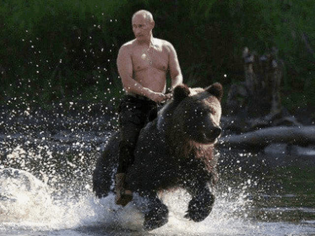 a shirtless man is riding a brown bear in the water