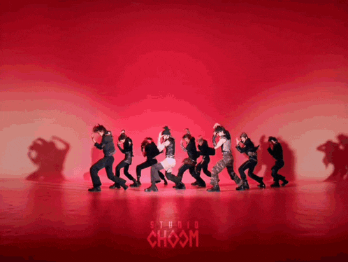 a group of people are dancing in front of a red background that says choom