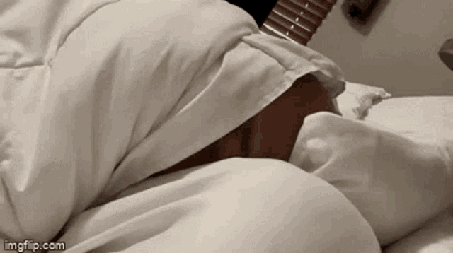 a person laying on a bed with a white blanket and a imgflip.com logo in the corner
