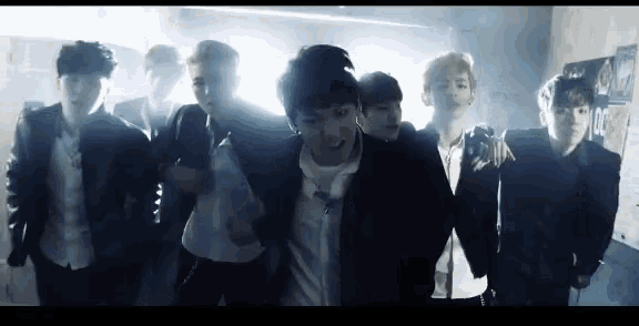 a group of young men are standing in a dark room .
