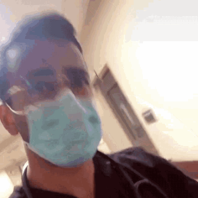 a man wearing a surgical mask and glasses