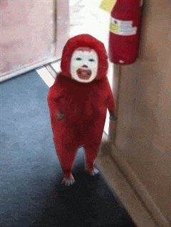 a child in a red costume is walking down a hallway