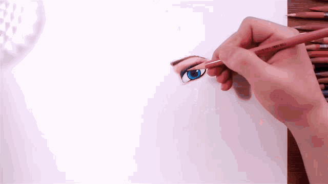 a person is drawing a woman 's eye with a pencil on a piece of paper .
