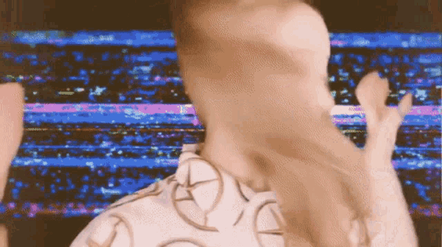 a blurry image of a man dancing in front of a colorful background .