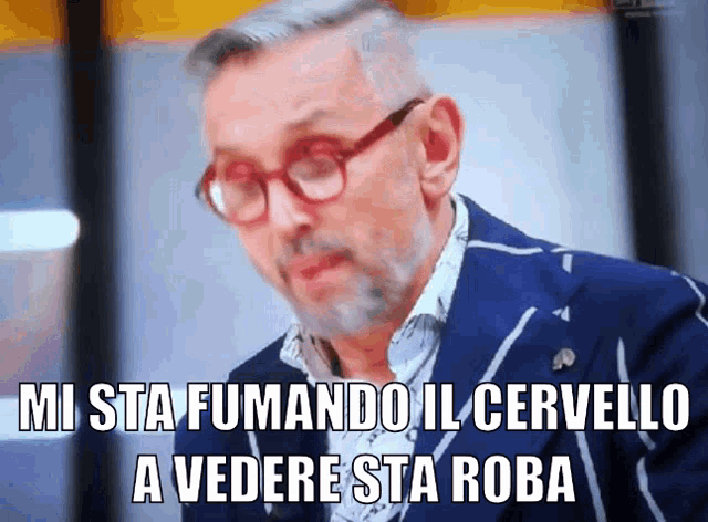 a man wearing glasses and a blue jacket says " mi sta fumando il cervello a vedere sta roba "