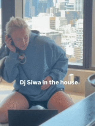 a woman wearing headphones is sitting in front of a laptop with the words dj siwa in the house written on the bottom