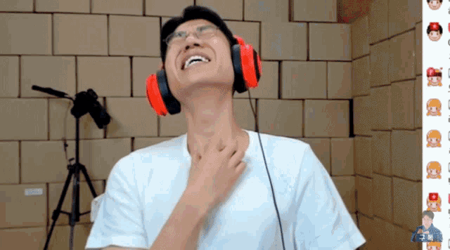 a man wearing red headphones and a white shirt is laughing