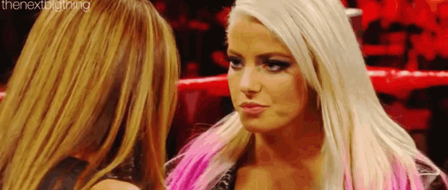 a couple of women are standing next to each other in a ring .