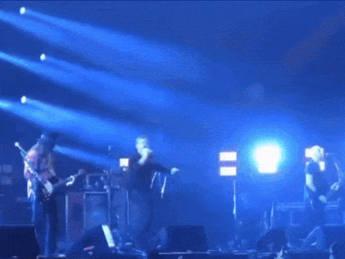 a group of people on a stage with blue lights