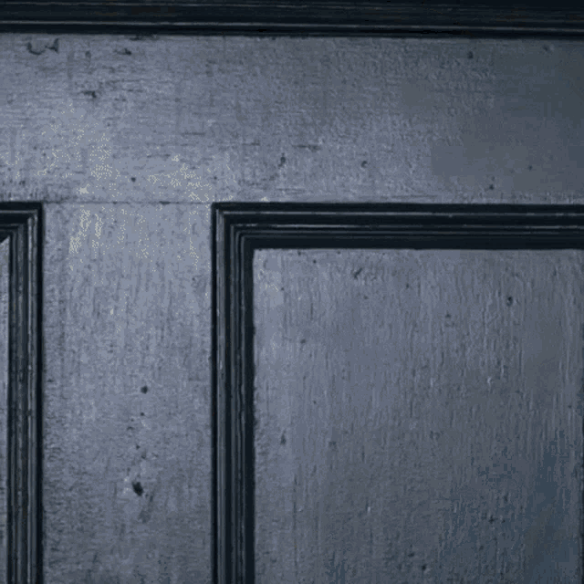 a man is standing in front of a door with a towel around his shoulder .